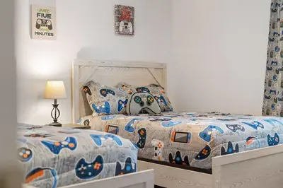 a bedroom with two beds with a batman comforter at Veranda Sunshine Escape - 5 BDR in Kissimmee