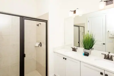 a bathroom with a shower and a sink and a mirror at Hunky Dory II in Orlando