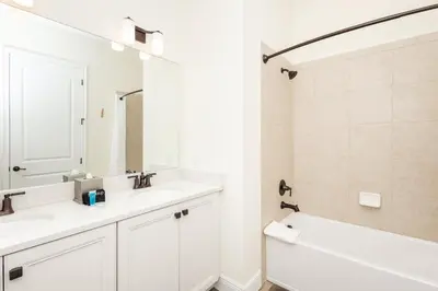a white bathroom with two sinks and a tub at Hunky Dory II in Orlando