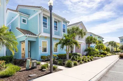 a blue house with palm trees in front of a street at Hunky Dory II in Orlando