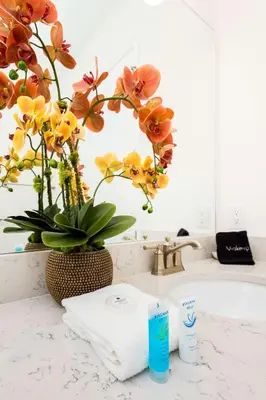 a sink with a towel and a vase with flowers at Trade Winds Life - Margaritaville in Orlando