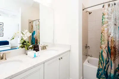 a white bathroom with two sinks and a shower at Trade Winds Life - Margaritaville in Orlando