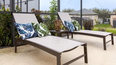 two white chairs with pillows on a balcony at Jewel of Emerald Island with Heated Pool in Kissimmee