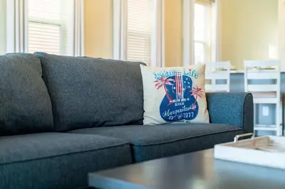 a blue couch with a pillow on it in a living room at Lafitte's Landing Lakeview Cottage - Lakefront in Orlando
