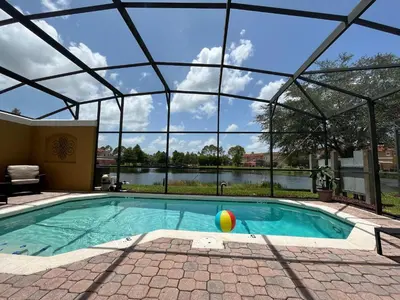 a swimming pool with a ball in front of a building at Create Lasting Magical Memories Resort Home for 8 in Kissimmee