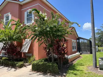 a pink house with a tree in front of it at Create Lasting Magical Memories Resort Home for 8 in Kissimmee