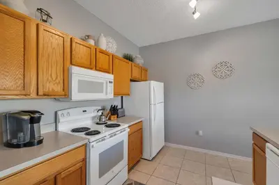 a kitchen with white appliances and wooden cabinets at Create Lasting Magical Memories Resort Home for 8 in Kissimmee