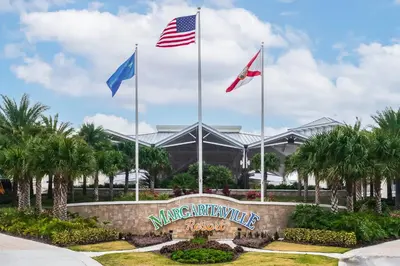 a sign with three flags in front of a building at The Sea Shelter - Sunny 4 BDR in Margaritaville in Orlando