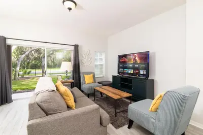 a living room with a couch and a flat screen tv at The Emerald Cove - Best Spot in Kissimmee in Kissimmee