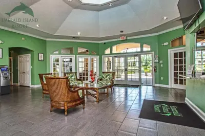 a room with a table and chairs and green walls at The Emerald Cove - Best Spot in Kissimmee in Kissimmee