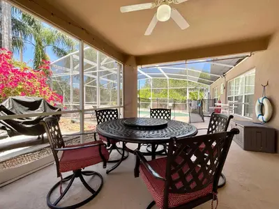a patio with a table and chairs and a ceiling fan at Marcellas Villa At Acadia Estates in Orlando
