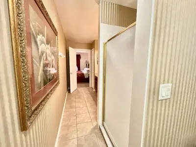 a hallway with a mirror and a painting on a wall at Marcellas Villa At Acadia Estates in Orlando