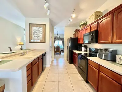a large kitchen with wooden cabinets and appliances at Marcellas Villa At Acadia Estates in Orlando