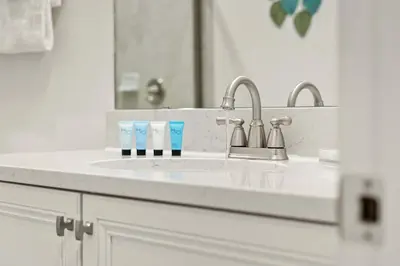 a bathroom sink with two toothbrushes and a mirror at Mint to Be in Orlando