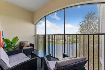 a balcony with two chairs and a large window at Minutes to Magic in Orlando