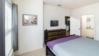 a bedroom with a bed and a dresser and a window at Moana's Hut - Miles from World's Best Theme Parks in Kissimmee