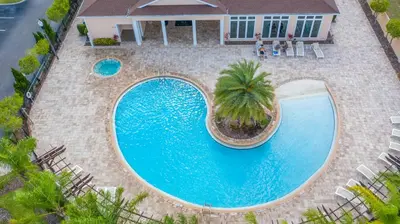an overhead view of a swimming pool with a palm tree at Moana's Hut - Miles from World's Best Theme Parks in Kissimmee