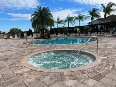 a swimming pool with a hot tub in a courtyard at Moana's Hut - Miles from World's Best Theme Parks in Kissimmee