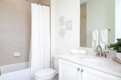 a white bathroom with a toilet and a sink at No Way Rose - Nearby Disney World & Universal in Orlando