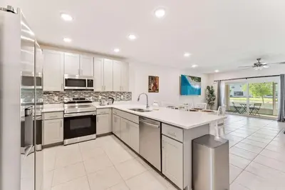 a large kitchen with white cabinets and a large island at Once Upon a Stay in Kissimmee