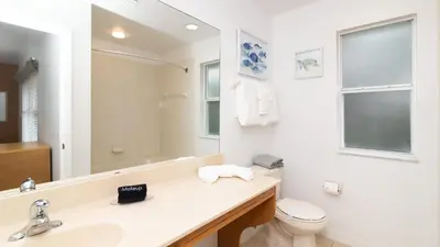 a bathroom with a sink and a toilet and a mirror at Orlando's Heartland with Amenities in Kissimmee