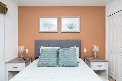 a bedroom with a bed with two nightstands and two lamps at Orlando's Heartland with Amenities in Kissimmee