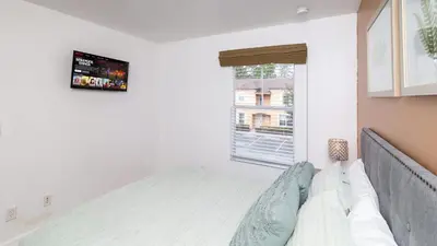 a white bedroom with a bed and a window at Orlando's Heartland with Amenities in Kissimmee