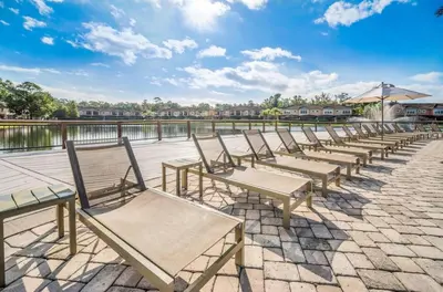 a row of benches sitting next to a body of water at Orlando's Heartland with Amenities in Kissimmee