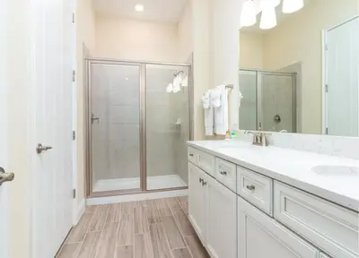 a white bathroom with a shower and a sink at Parrotfish Place - Stay for 6 in Orlando