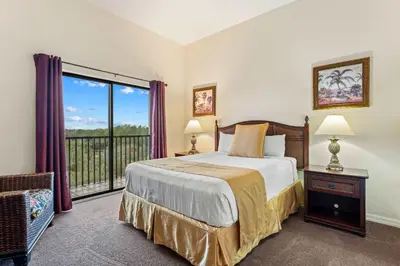 a bedroom with a bed and a balcony at Peaceful Horizons at Caribe Cove in Kissimmee