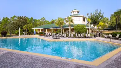 a large swimming pool in front of a house at Peaceful Horizons at Caribe Cove in Kissimmee