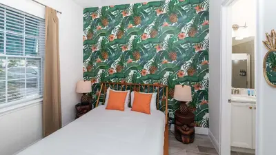 a bedroom with a bed with orange pillows at Rum Runners and Margaritas in Orlando