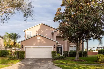 a house with a tree and a garage at Serendipity at Acadia - Family getaway in Orlando