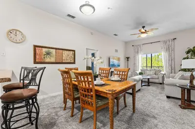 a dining room and living room with a table and chairs at Slice Of Sunshine At Caribe Cove in Kissimmee