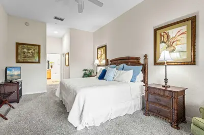 a bedroom with a large bed with blue pillows at Slice Of Sunshine At Caribe Cove in Kissimmee