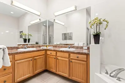 a bathroom with two sinks and a large mirror at Slice Of Sunshine At Caribe Cove in Kissimmee