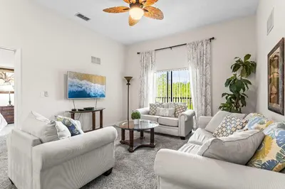 a living room with two couches and a table at Slice Of Sunshine At Caribe Cove in Kissimmee