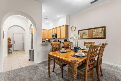 a kitchen and dining room with a wooden table and chairs at Slice Of Sunshine At Caribe Cove in Kissimmee