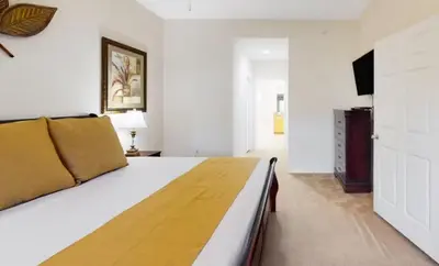 a bedroom with a large bed and a television at Sunny Haven At Caribe Cove in Kissimmee