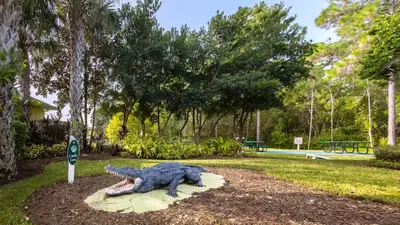 a statue of a crocodile on a rock in a park at Sunny Haven At Caribe Cove in Kissimmee