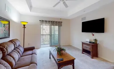a living room with a couch and a flat screen tv at Sunny Haven At Caribe Cove in Kissimmee