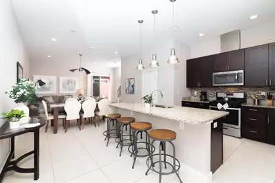 a kitchen with a large island with bar stools at Sunrise in Kissimmee - Near Disney World in Orlando