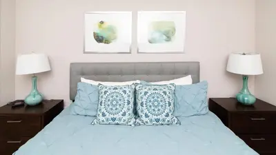 a bedroom with a bed with blue pillows and two lamps at Sunrise in Kissimmee - Near Disney World in Orlando