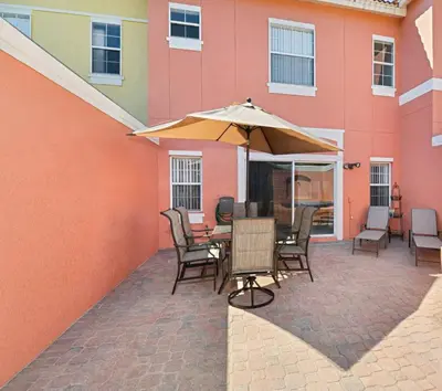 a patio with a table and chairs and an umbrella at Terra Verde - Resort Amenities & More in Kissimmee