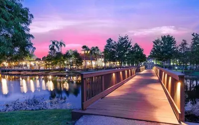 a wooden bridge over a pond at night at Terra Verde - Resort Amenities & More in Kissimmee
