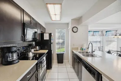 a kitchen with a sink and a stove top oven at 2466 Sweetwater in Kissimmee