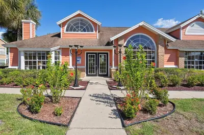 a house with three plants in front of it at 2466 Sweetwater in Kissimmee