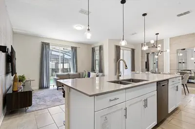 a kitchen with a sink and a living room at 4 Bedrooms - 3 Bathrooms - Storey Lake 4818Ml in Kissimmee