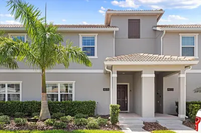a house with a palm tree in front of it at 4 Bedrooms - 3 Bathrooms - Storey Lake 4818Ml in Kissimmee