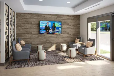 a living room with a tv on a brick wall at Candlewood Suites Orlando North - Winter Park by IHG in Orlando